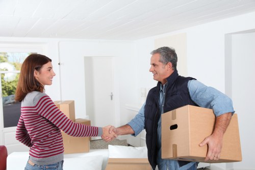 Mover arranging boxes and furniture inside a Hackney flat removal van