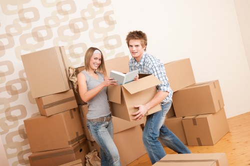 Professional movers carrying furniture down stairs in a Hackney apartment building